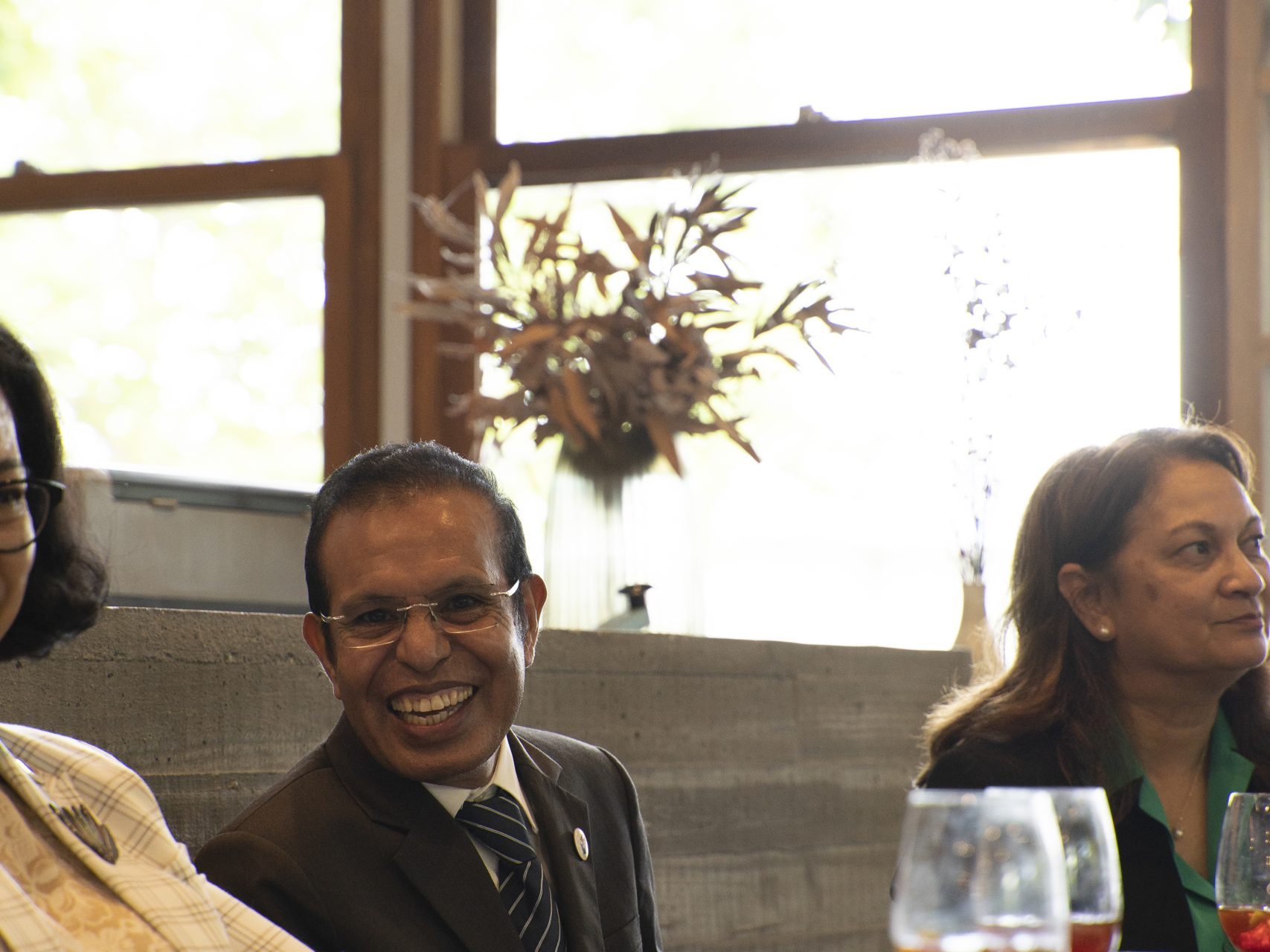 Three people at a table, enjoying drinks and conversation.